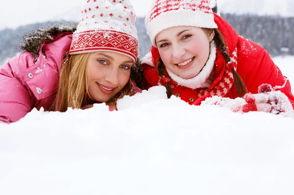 Twee vrouwen samen vaststelling op witte sneeuw — Stockfoto