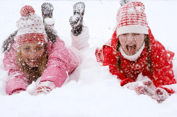 Dos mujeres acostadas juntas sobre nieve blanca —  Fotos de Stock