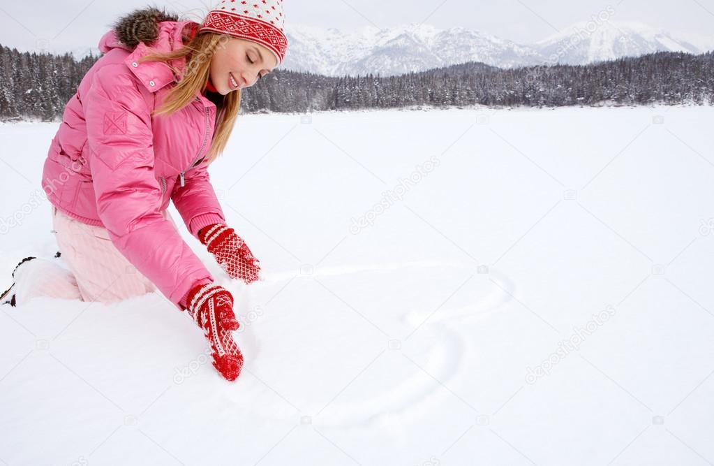 Woman drawing a heart on the snow