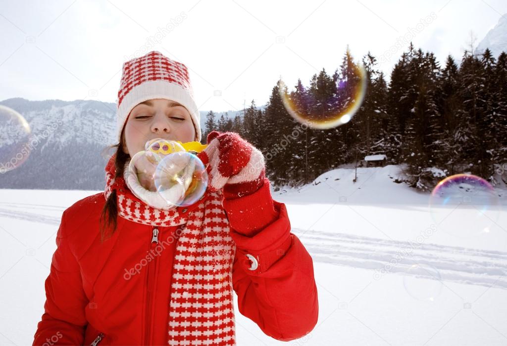 Woman blowing soap bubbles outdoors