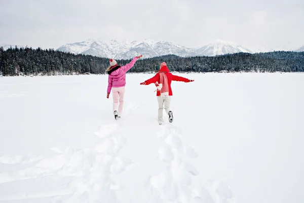 Zwei Frauen laufen gemeinsam über einen zugefrorenen See — Stockfoto