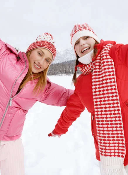 Две девушки играют в игры и веселятся зимой — стоковое фото
