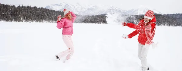 Dwie dziewczyny, gry i zabawy zimą — Zdjęcie stockowe