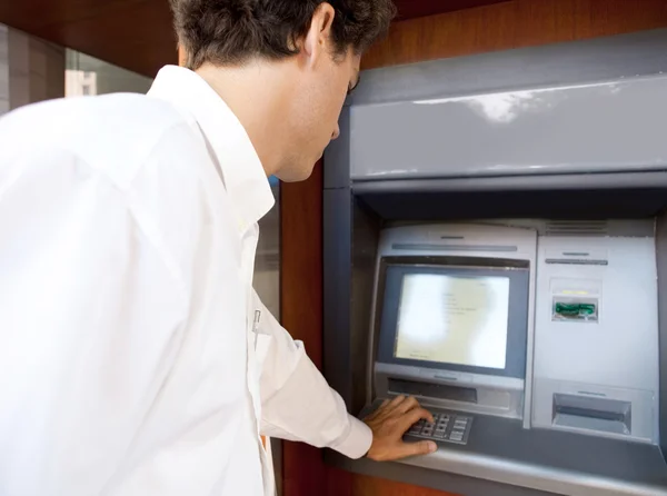 Businessman using an atm machine — Stock Photo, Image