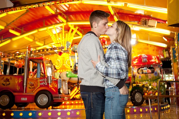 Paar staande door carrousel — Stockfoto