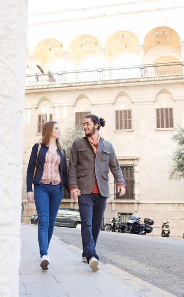 Casal andando passou edifícios — Fotografia de Stock