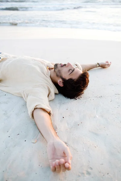 Mann legt sich auf Strand — Stockfoto