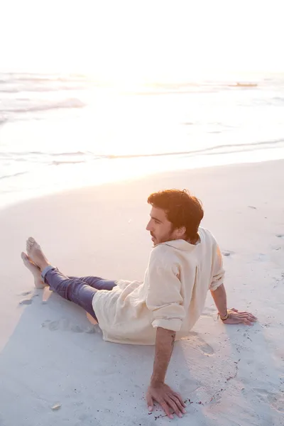 坐在沙滩上的年轻人 — 图库照片