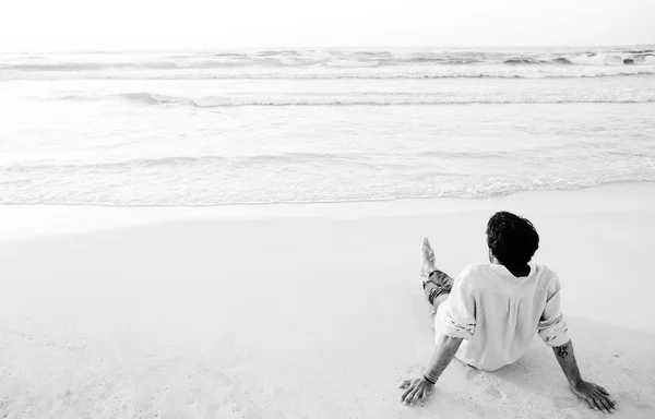坐在沙滩上的年轻人 — 图库照片