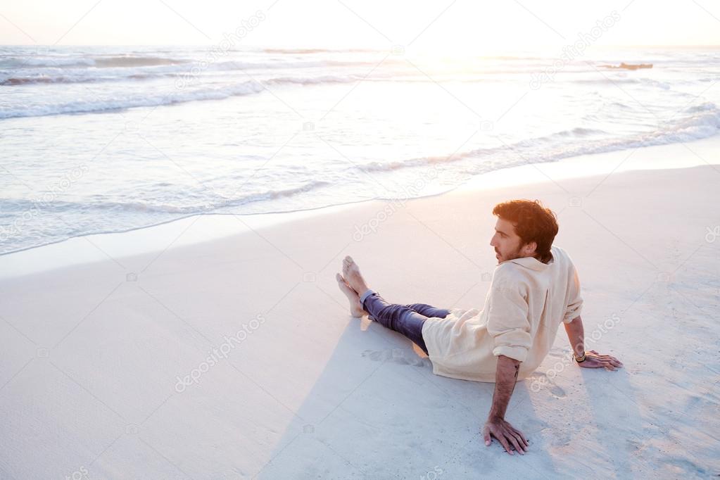 Young man sitting on beach