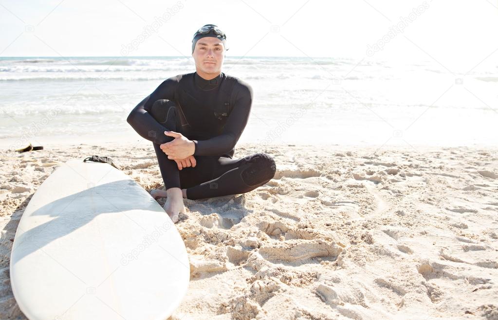 Young surfer man sitting