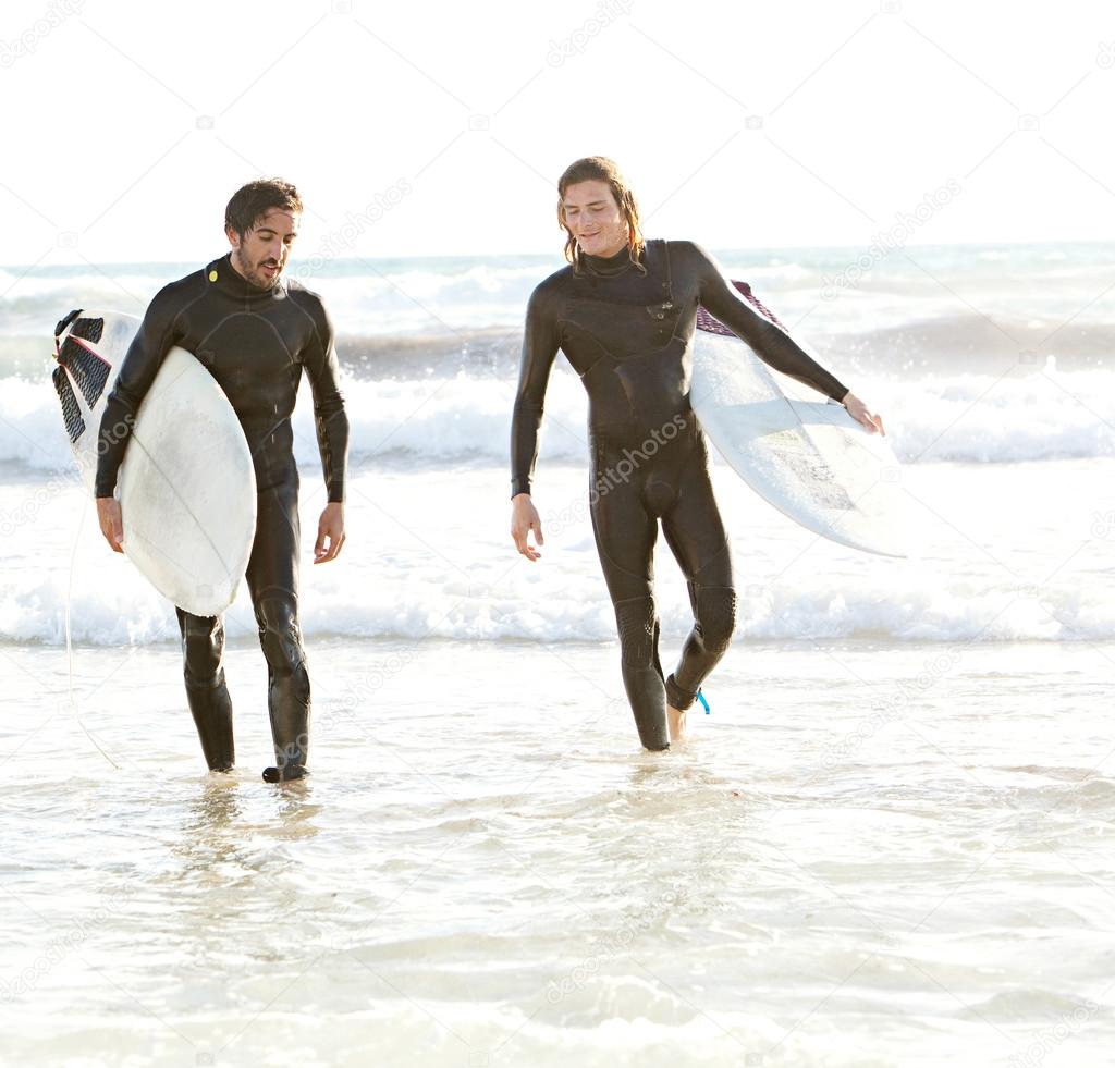 Surfers walking back
