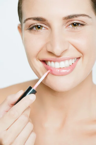 Mujer aplicando lápiz labial rosa —  Fotos de Stock