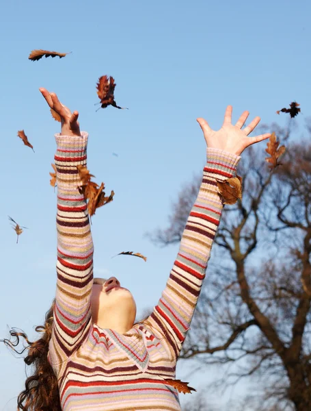 Chica lanzando hojas de otoño —  Fotos de Stock