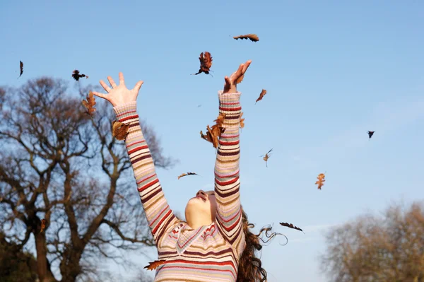 Girl throwing  autumn leaves — Stock Photo, Image