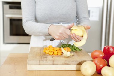 Womans hands pealing potatoes clipart