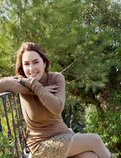 Frau sitzt auf Gartenbank — Stockfoto
