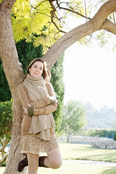 Woman leaning on  tree trunk — Stock Photo, Image