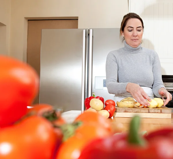 Frau schält Kartoffeln — Stockfoto