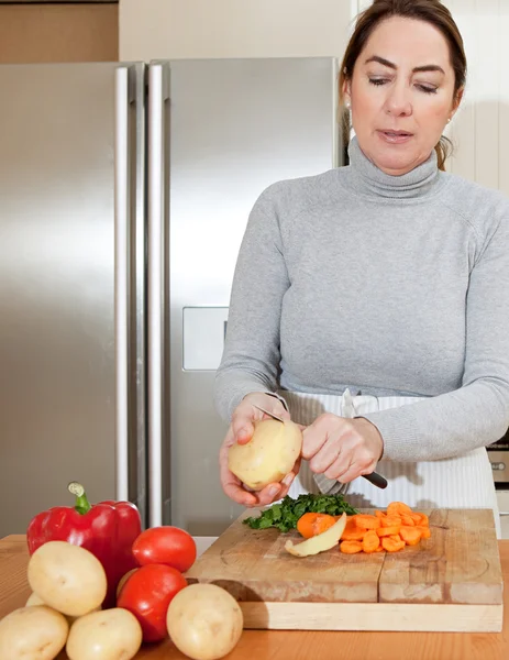 Frau schält Kartoffeln — Stockfoto