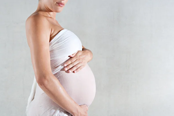 Mulher grávida sem rosto segurando sua barriga — Fotografia de Stock