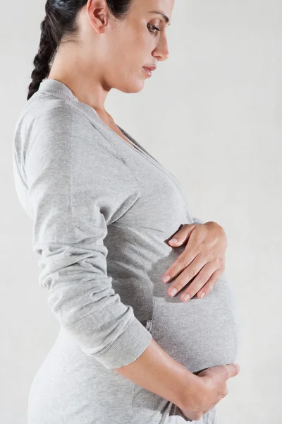 Zwangere vrouw een grijze katoen badkamer gewaad dragen — Stockfoto