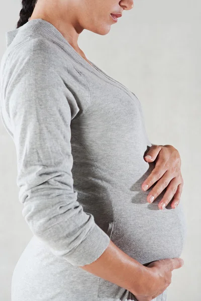 Bir gri pamuk elbise giyen hamile kadın — Stok fotoğraf