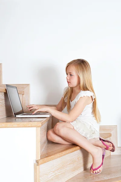 Menina criança usando um computador portátil — Fotografia de Stock