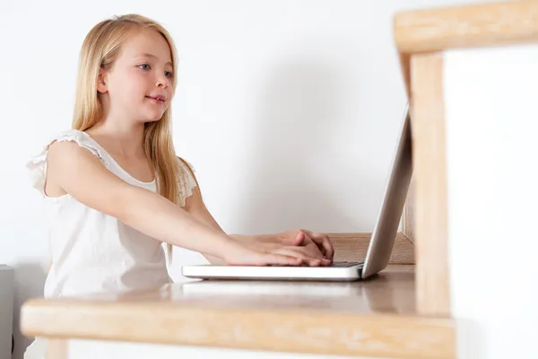 Jong meisje met een laptopcomputer — Stockfoto