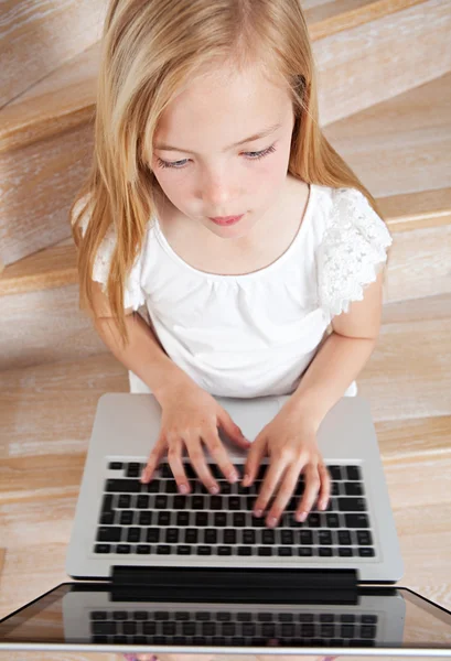 Menina criança usando um computador portátil — Fotografia de Stock