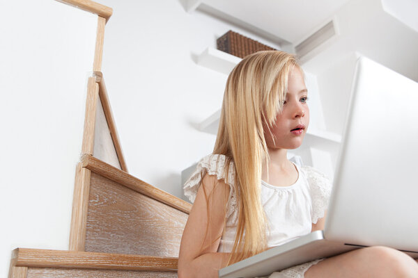 Girl child concentrated in using a laptop