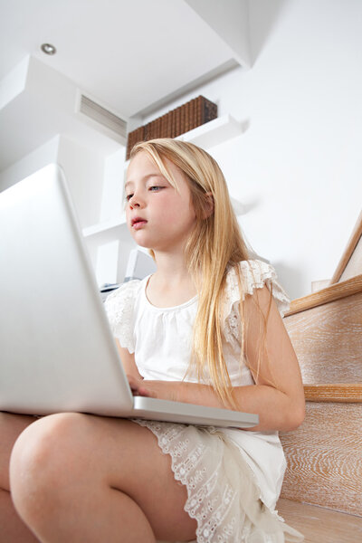 Girl child concentrated in using a laptop