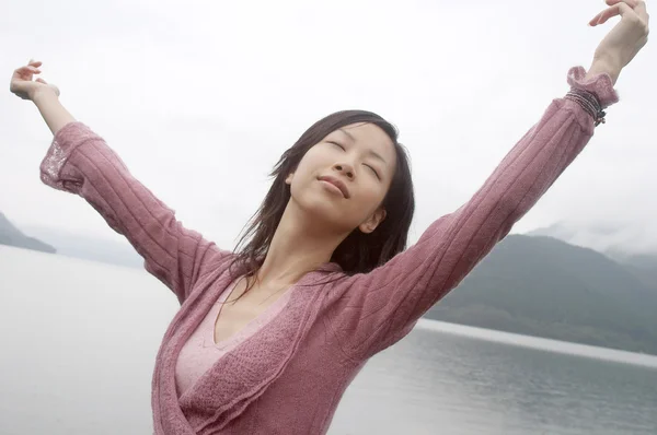 Junge Frau steht an einem See — Stockfoto