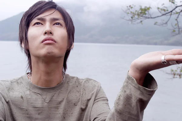Японский юноша, стоящий у озера — стоковое фото