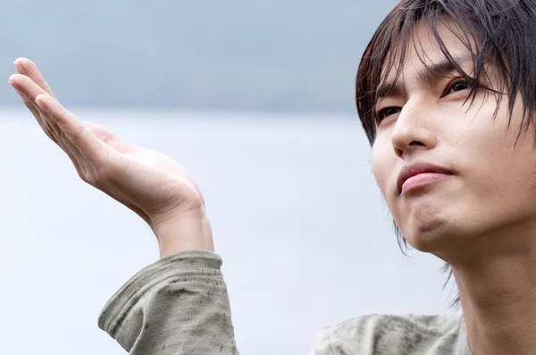 Японский юноша, стоящий у озера — стоковое фото