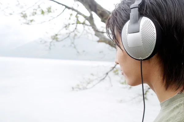Asian man listening to music with his headphones — Stock Photo, Image