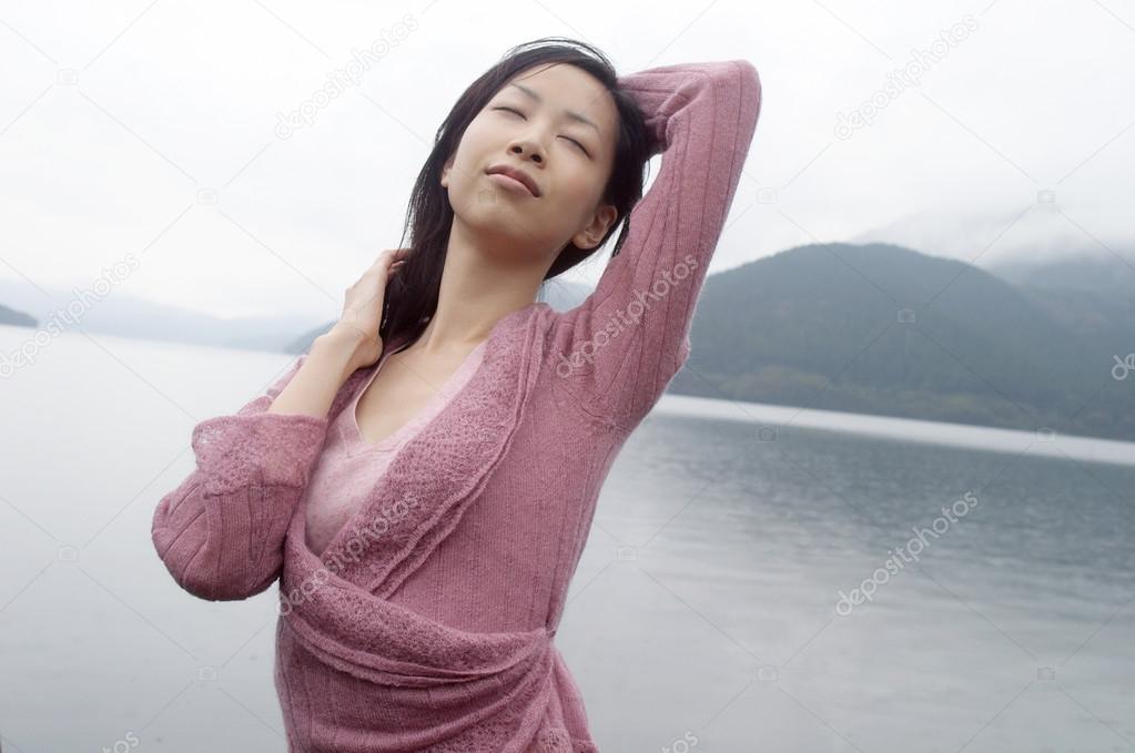 Young woman standing by a lake