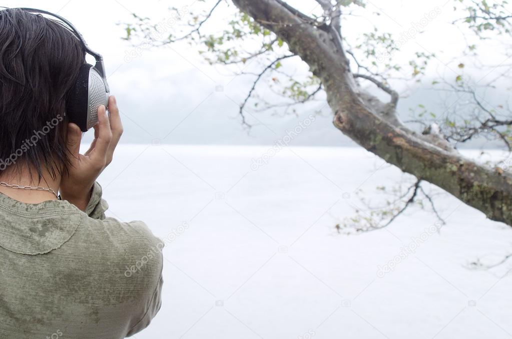 Asian man listening to music with his headphones