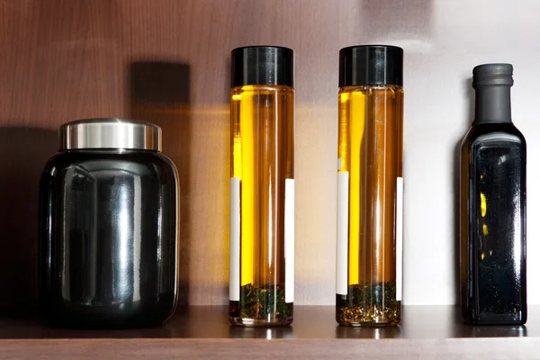 Kitchen shelf with transparent glass olive oil — Stock Photo, Image