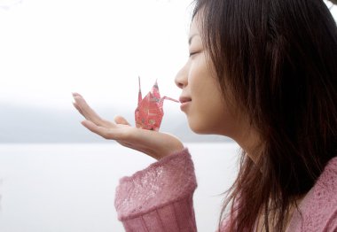 Bir origami swan tutan kadın
