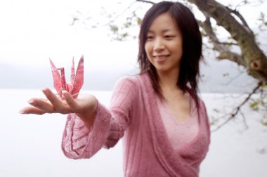 Bir origami swan tutan kadın