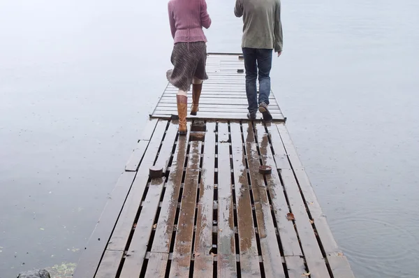 Couple walking together on a wooden pier — Stock Photo, Image