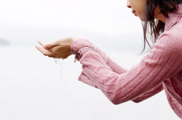 Femme debout près d'un lac et des montagnes — Photo