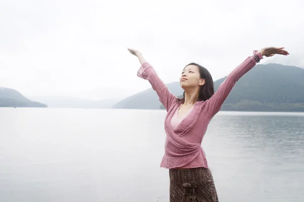 Женщина стоит у озера и гор — стоковое фото