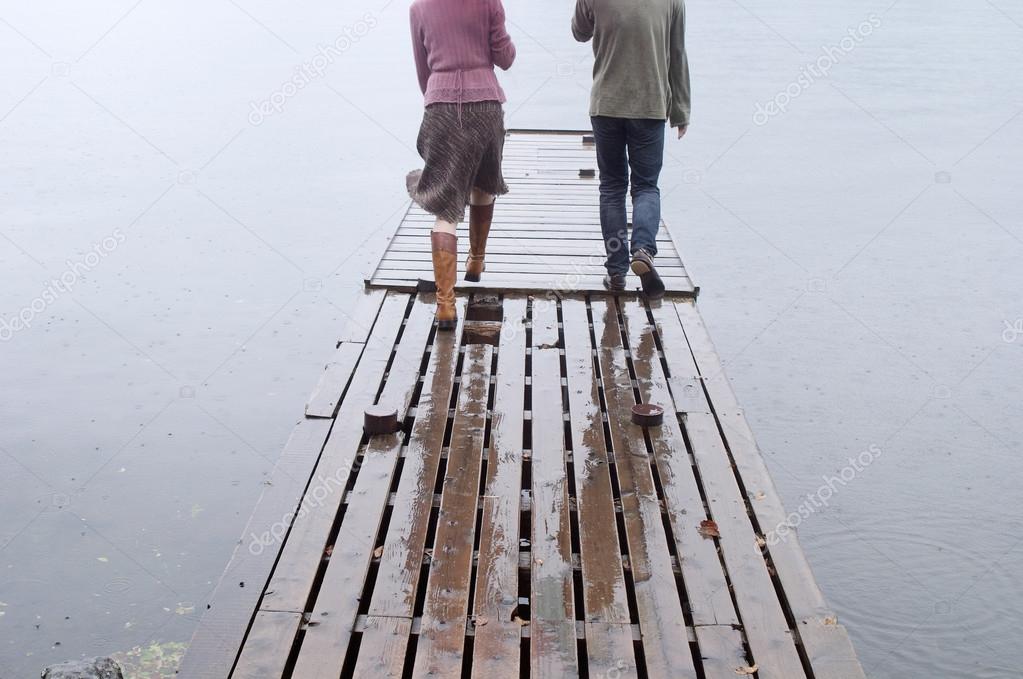 Couple walking together on a wooden pier