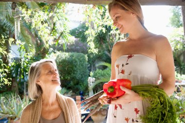 Mother and daughter together in a home garden clipart