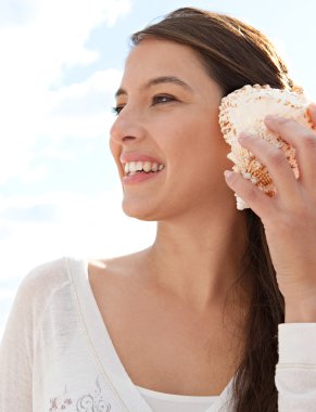 Woman holding a sea shell clipart