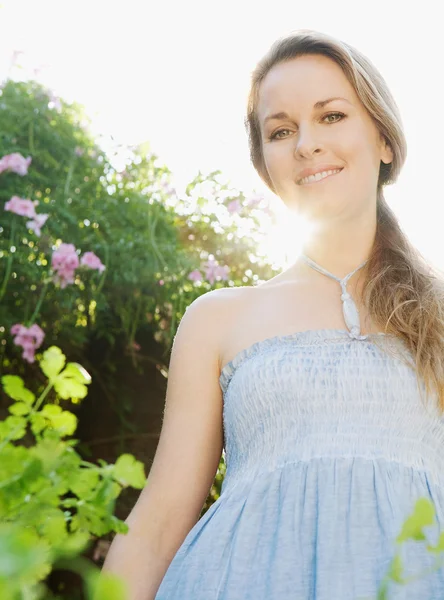 Mujer de pie en un jardín verde — Foto de Stock