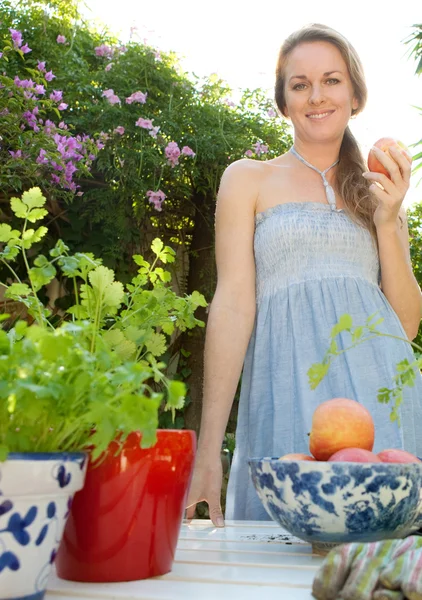 Woman standing in her home garden — Stock Photo, Image