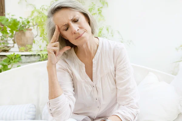 Frau sitzt zu Hause auf einem Sofa — Stockfoto